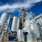 Tanks and agricultural silos of grain elevator storage. Loading facility building exterior. View from below.